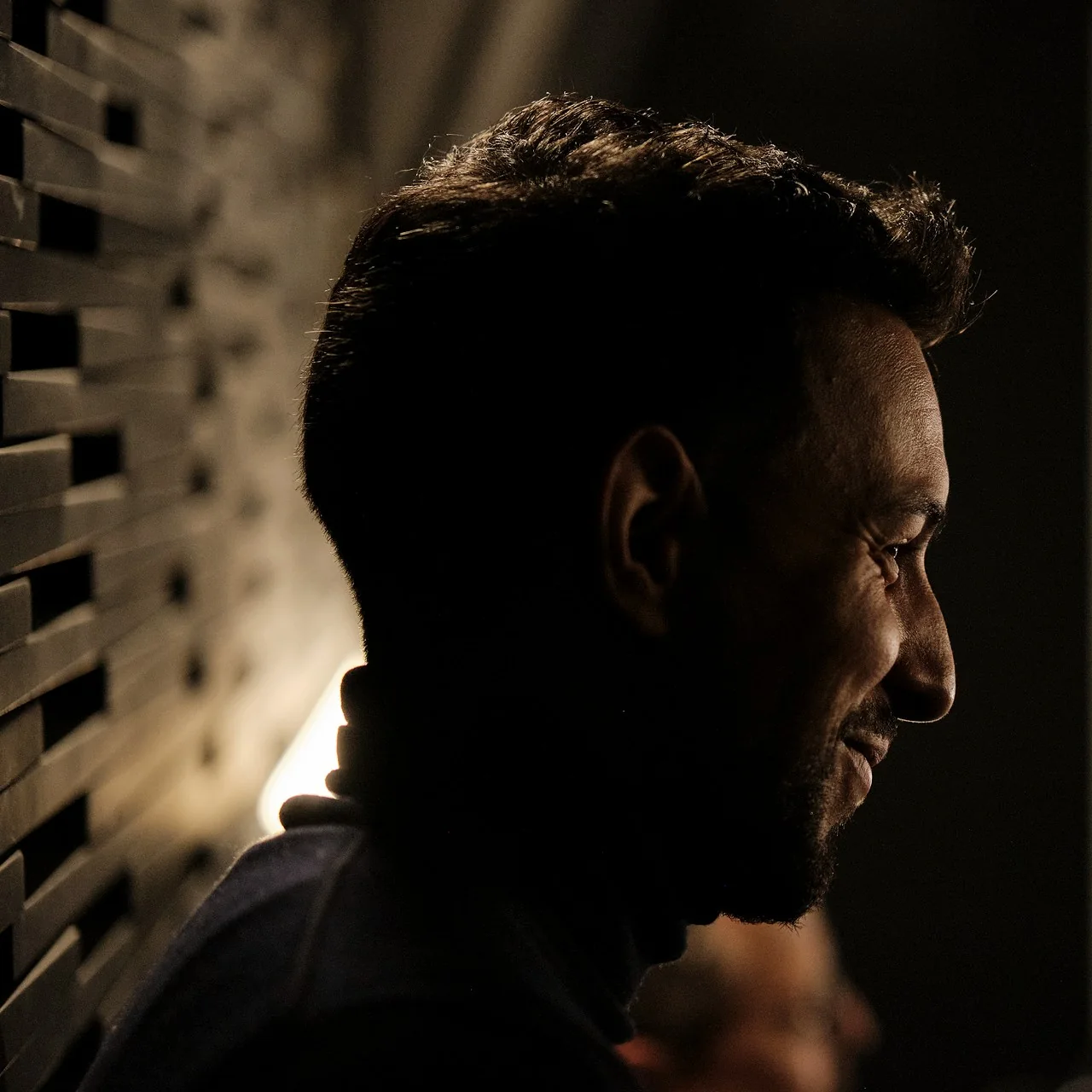 A guest speaking in profile under warm light