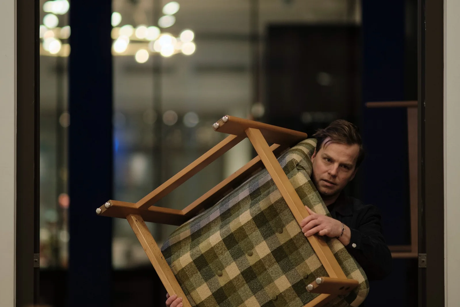 A crew member moving a chair on the set