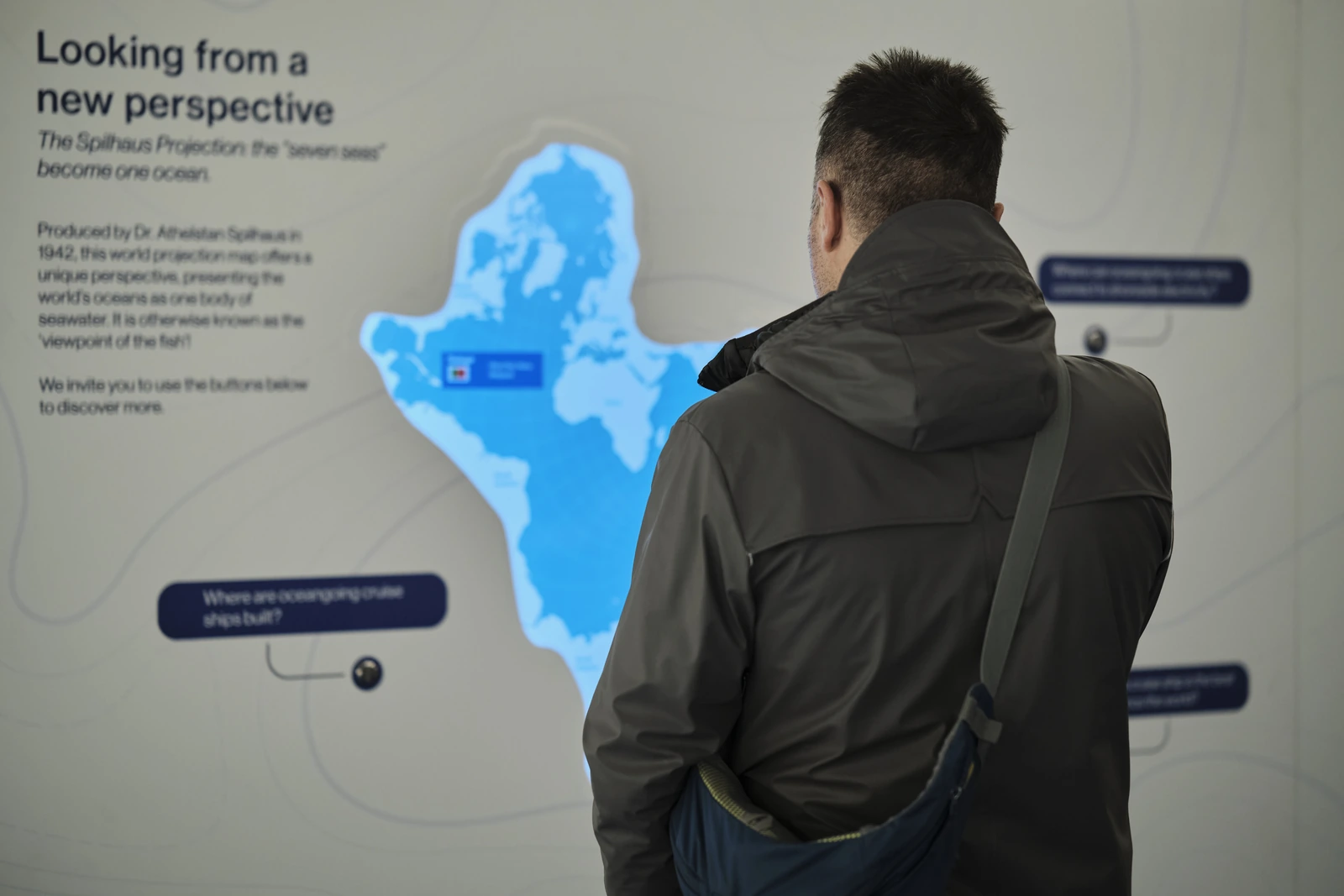 A visitor reading the Spilhaus projection map wall