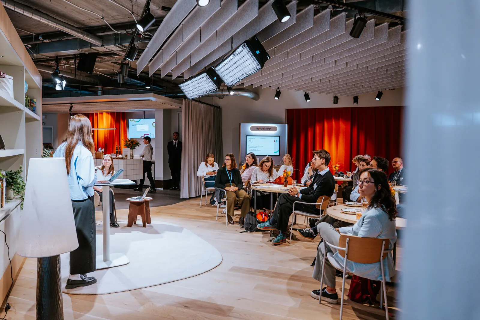 A session in the full room, the audience seated and the stage lit at the far end
