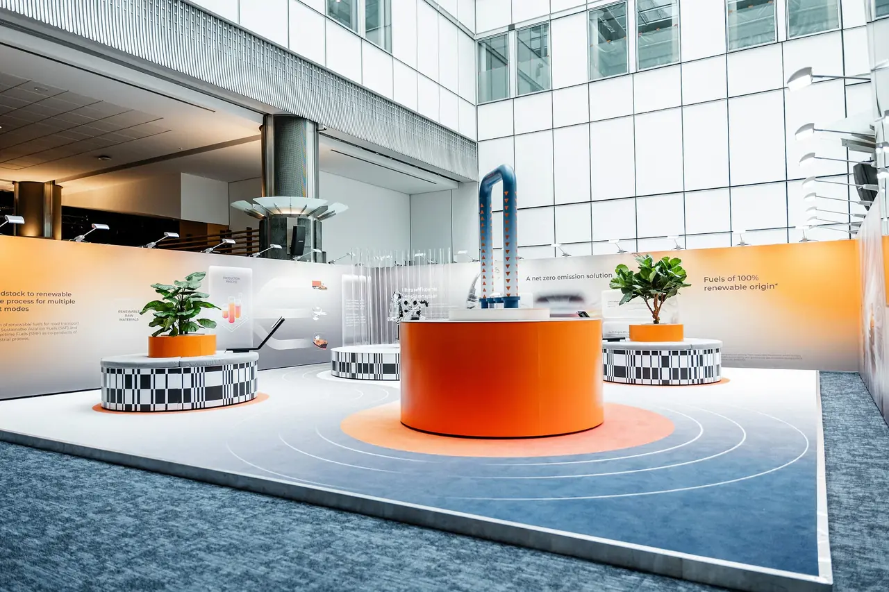 A Bump installation inside the European Parliament — circular orange plinths and planters on a printed floor