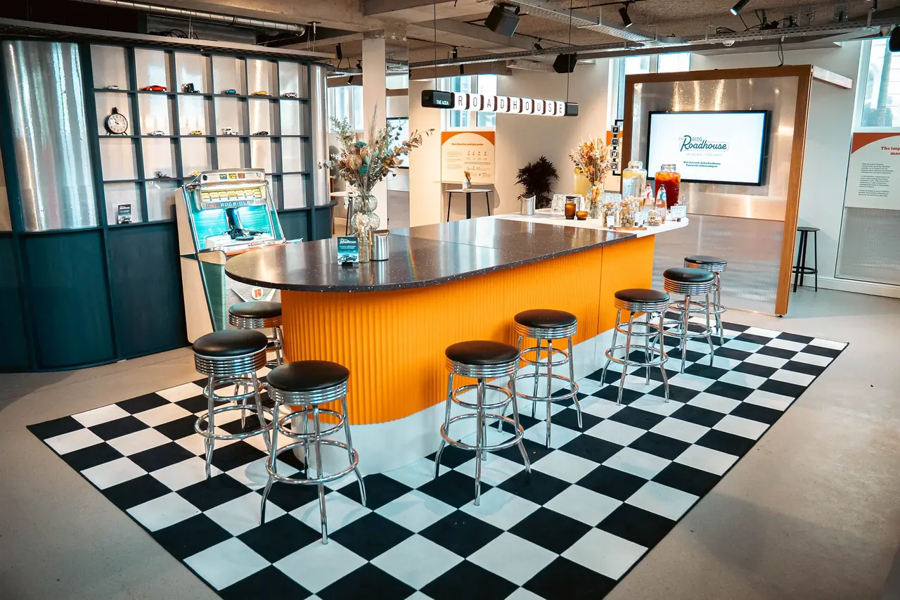 A policy pop-up built as a roadhouse diner — curved bar, chrome stools and a chequerboard floor